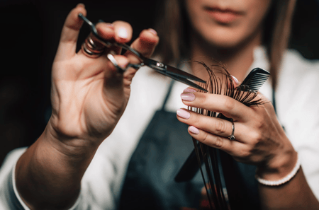 woman cutting hair hands holding scissors