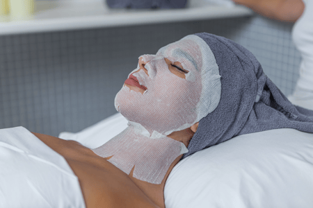 woman with sheet mask over face during spa treatments